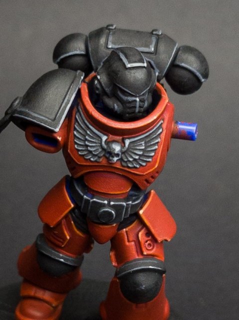 How I paint a Space Marine, Layers and edge highlights, step 4: Red: dots of Deep Orange Intense mixed 1:1 with Ice Yellow on the brightest corners. Black: Administratum Grey dots on…